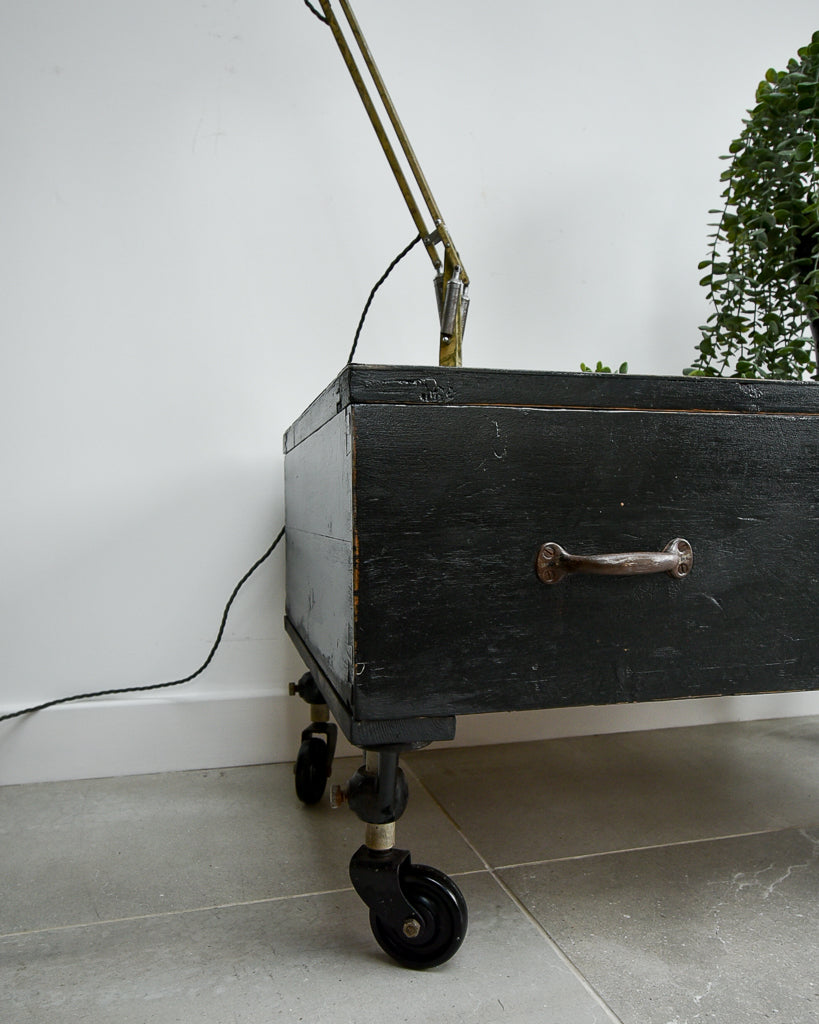 Ebonised black industrial coffee chest table on wheels with vintage handles