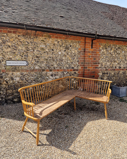 1950s Arno Lambrecht corner bench with rush seating in vintage workshop setting, mid century wooden L-shaped bench detail