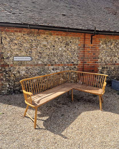 1950s Arno Lambrecht corner bench with rush seating in vintage workshop setting, mid century wooden L-shaped bench detail