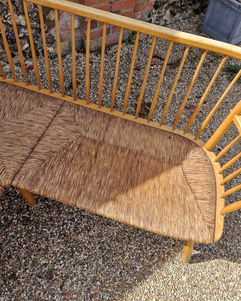 1950s Arno Lambrecht corner bench with rush seating in vintage workshop setting, mid century wooden L-shaped bench detail