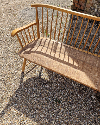 1950s Arno Lambrecht corner bench with rush seating in vintage workshop setting, mid century wooden L-shaped bench detail
