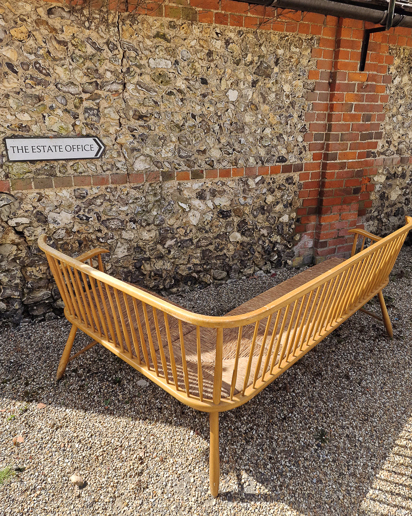 1950s Arno Lambrecht corner bench with rush seating in vintage workshop setting, mid century wooden L-shaped bench detail