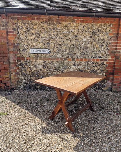 German solid oak dining table with three plank top and trestle base, paired with rustic wooden benches in farmhouse setting